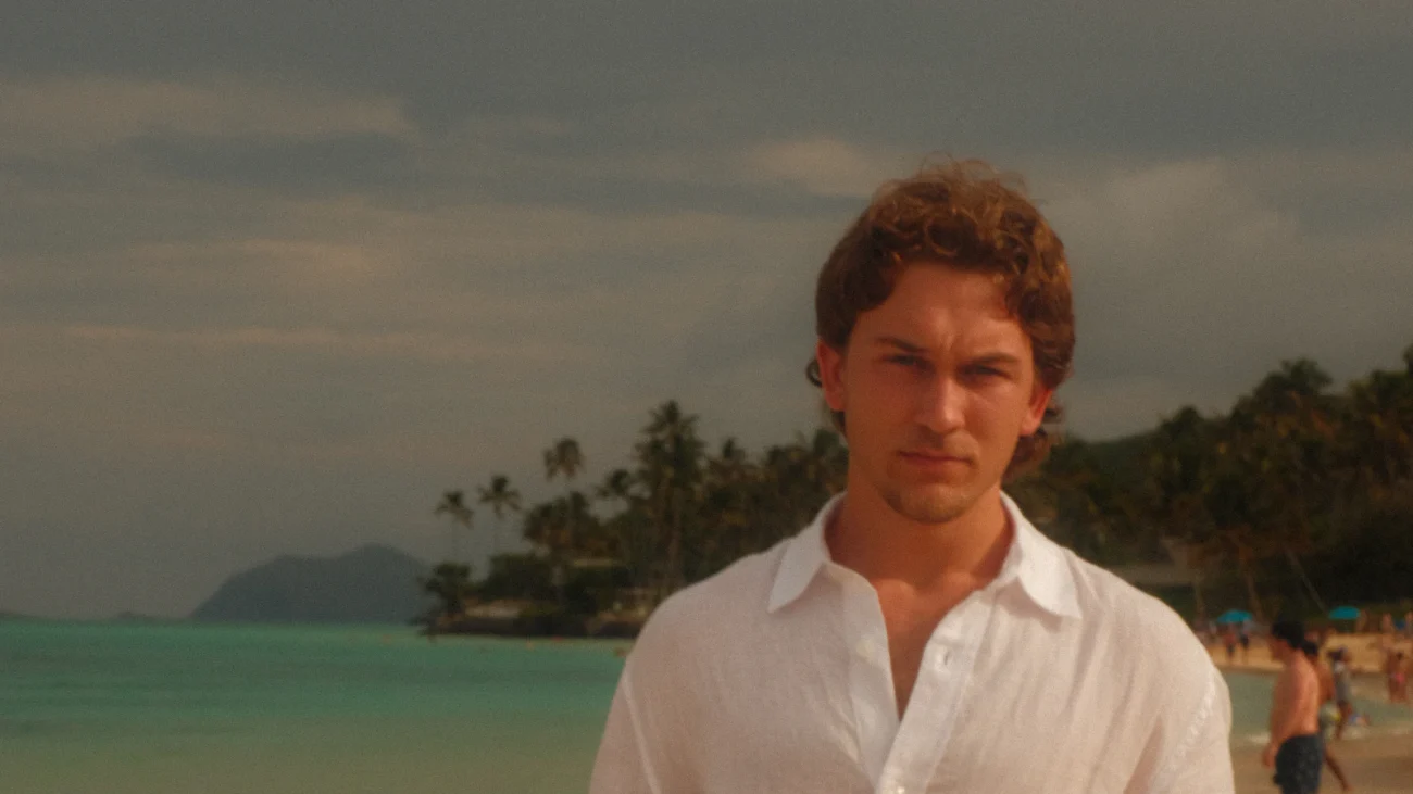 Hombre con camisa blanca fresca en una playa tropical