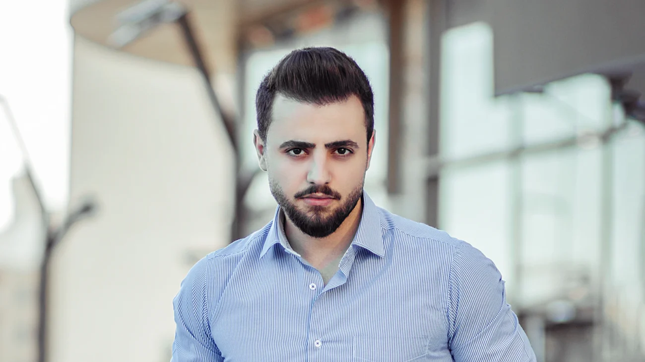 Hombre con camisa azul claro de manga larga y las mangas recogidas