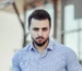 Hombre con camisa azul claro de manga larga y las mangas recogidas