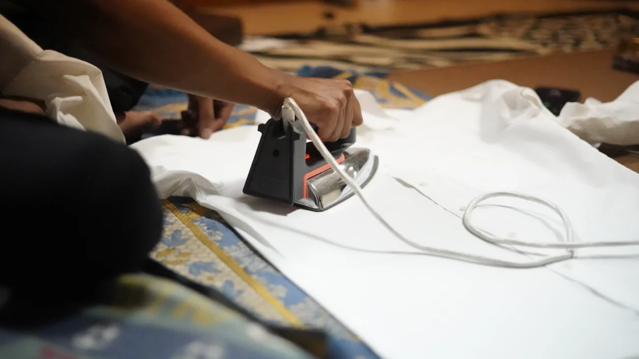 Persona planchando una camisa blanca de algodón